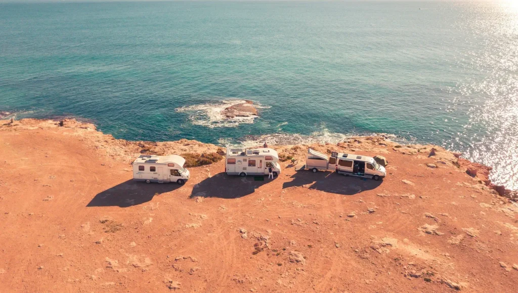 2 Class C RVs and a Class B RV overlooking a cliff